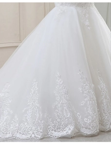 Vue détaillée de l'ourlet de robe sirène blanche avec dentelle florale et paillettes