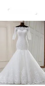 Détail d'une robe de mariée sirène blanche à épaules dénudées avec broderie de dentelle