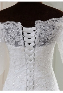 Détail d'une robe de mariée sirène blanche avec broderie en dentelle et corset lacé