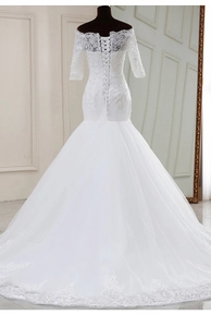 Détail d'une robe de mariée sirène à épaules dénudées avec dentelle et laçage au dos