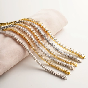 Classic tennis bracelet with round cubic zirconia in gold and silver finishes on a pink stand
