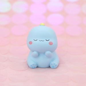 Cute blue dinosaur cake topper toy sitting with closed eyes for birthday decoration