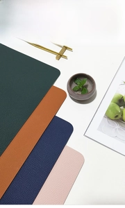 Close-up of multicolored leather placemats with lychee grain texture and rounded corners