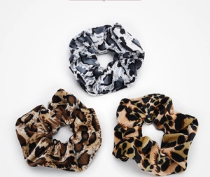 Close-up of leopard print plush scrunchies set showing soft texture and fuzzy patterns