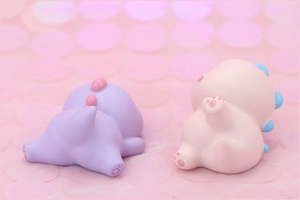 Close-up of pink and purple dinosaur figurines showing back and tail texture details