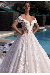 Detailed close-up of intricate lace embroidery and sparkling tassel sleeves on ivory gown