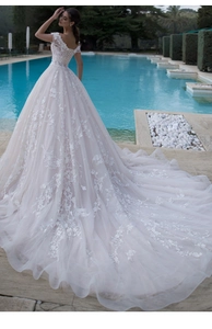 Detail of elegant lace wedding dress featuring floral embroidery and a long train