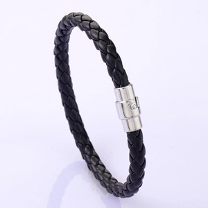 Macro view of woven black leather band with a polished silver skull metal buckle