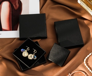 Litchi pattern black jewelry box detail with square and rectangular boxes on silk fabric