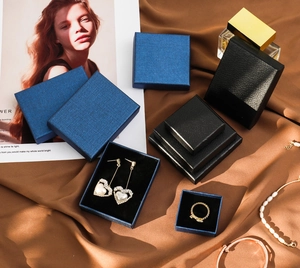 Detailed view of elegant black and blue textured jewelry boxes on premium satin fabric