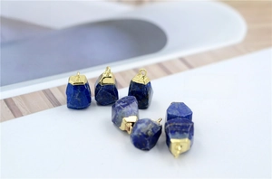 Macro shot of natural Lapis Lazuli stone charms with golden metal caps for jewelry