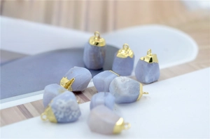 Close-up of natural blue chalcedony stone pendants with gold metal caps and rings
