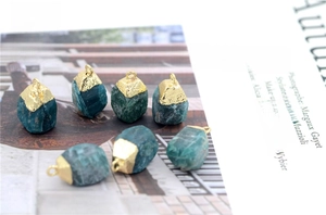 Detailed view of raw blue apatite stone pendants scattered on a fashion magazine page