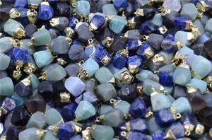 Close-up of assorted raw natural crystal stone pendants with gold metal caps