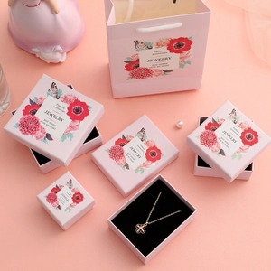 Pink floral jewelry packaging set with various boxes and matching paper gift bags