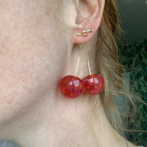 Sweet resin cherry drop earrings with gold wires shown on a model for a fresh summer look