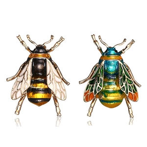 Detailed macro view of bee-shaped insect brooches in gold-black and blue-green enamel finish