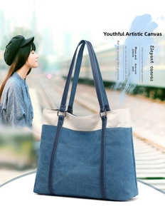 Detail of blue and beige canvas tote bag with slim dark blue leather shoulder straps