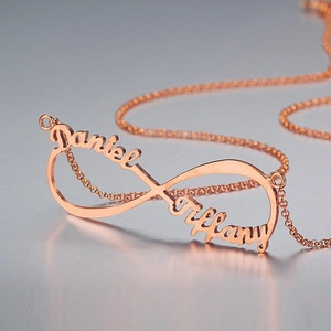 Macro shot of rose gold infinity necklace customized with names Daniel and Tiffany