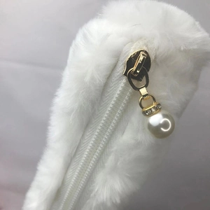 White plush cosmetic bag with pearl zipper pull and rhinestone ring detail