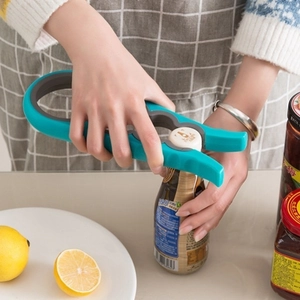 Blue and gray 4-in-1 multifunctional jar opener being used to open a bottle in a kitchen