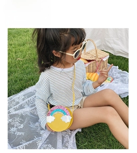 Close-up of yellow round crossbody bag with sequin rainbow and clouds for little girls