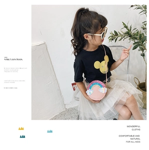 Pink round crossbody bag with sequined rainbow and clouds on a child summer outfit