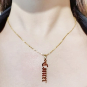 Close-up of golden Cancer zodiac nameplate necklace on a model's collarbone