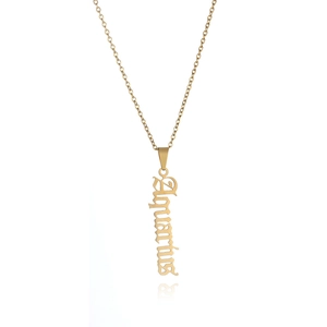 Macro detail of gothic style Aquarius word pendant in polished golden stainless steel