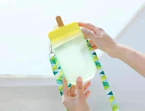 Close-up of mint green popsicle-shaped water bottle with colorful geometric strap