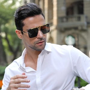 Close-up of square sunglasses with gold metal bridge and black lenses on model