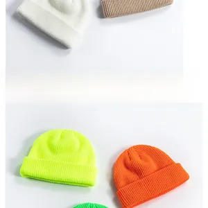 Close-up of ribbed knit beanies in various colors including beige, orange, and neon yellow