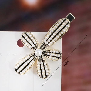 Close-up of 7cm floral pearl hair clip with gold alloy petals and black line accents
