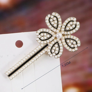 Detail of 7.2cm clover pearl hair clip with gold alloy base and black enamel inlay