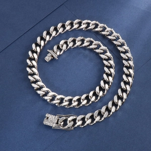 Macro shot of silver Cuban link chain with sparkling diamond-encrusted dragon clasp