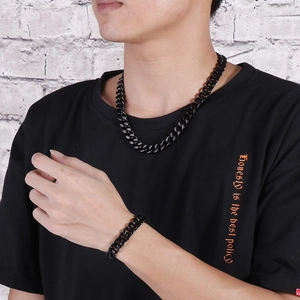 Detail of street style black cuban chain set including necklace and bracelet on model