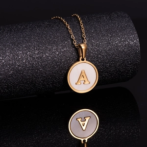 Golden stainless steel letter A necklace with mother of pearl pendant on black display