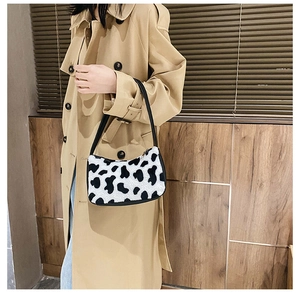 Chic faux fur zebra print underarm bag shown with a khaki trench coat for a stylish look