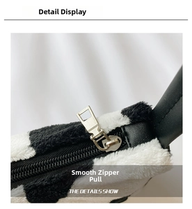 Detail of silver alloy zipper and black faux leather trim on zebra plush handbag