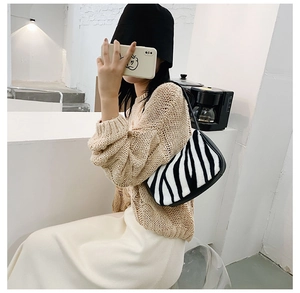Zebra pattern faux fur underarm bag shown with stylish outfit in a modern setting