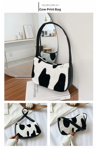Detail of plush cow print faux fur handbag with black PU leather strap and metal zipper