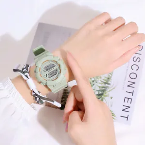 Light green digital sports watch with square dial and weekday display on female wrist