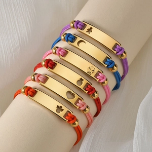 Dettaglio di placche dorate 18K con motivi traforati su bracciali in corda intrecciata