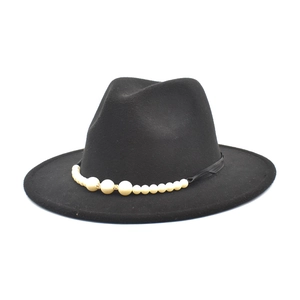 Detail of black wool fedora hat featuring elegant faux pearl beading and gold accents