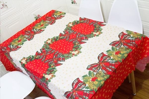 Detail of Christmas tablecloth with holly wreaths, pine cones and red plaid bows patterns