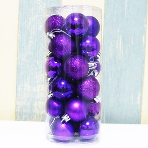 Close-up of purple Christmas ball ornaments in mixed finishes inside clear plastic packaging