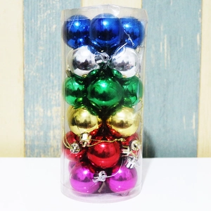 Close-up of assorted glossy colorful Christmas ball ornaments in a clear cylindrical box