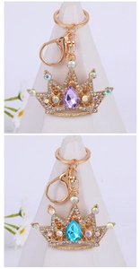 Detailed macro view of gold-plated crown keychains with sparkling crystal and gemstone inlay