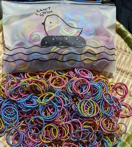Macro detail of high-elasticity braided hair ties in various colors with zip storage bag