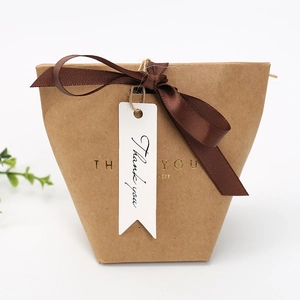 Detailed view of kraft gift box with ribbon bow and thank you swallowtail paper tag